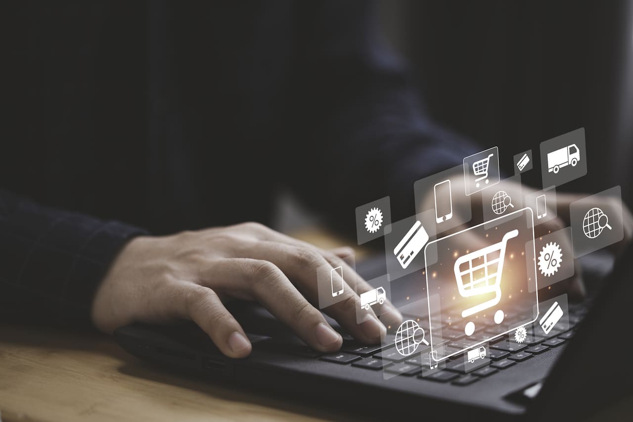 Acheteur utilisant un ordinateur portable pour effectuer un achat en ligne avec un chariot