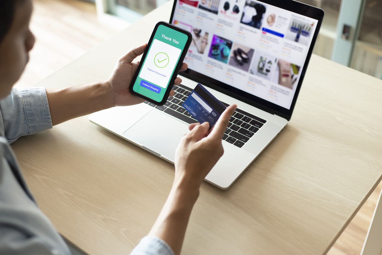 Mains utilisant un téléphone pour effectuer un paiement en ligne avec une carte de crédit